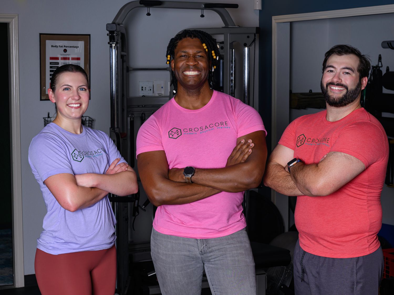 Two clients standing with Brandon in the clinic gym, relaxed and smiling