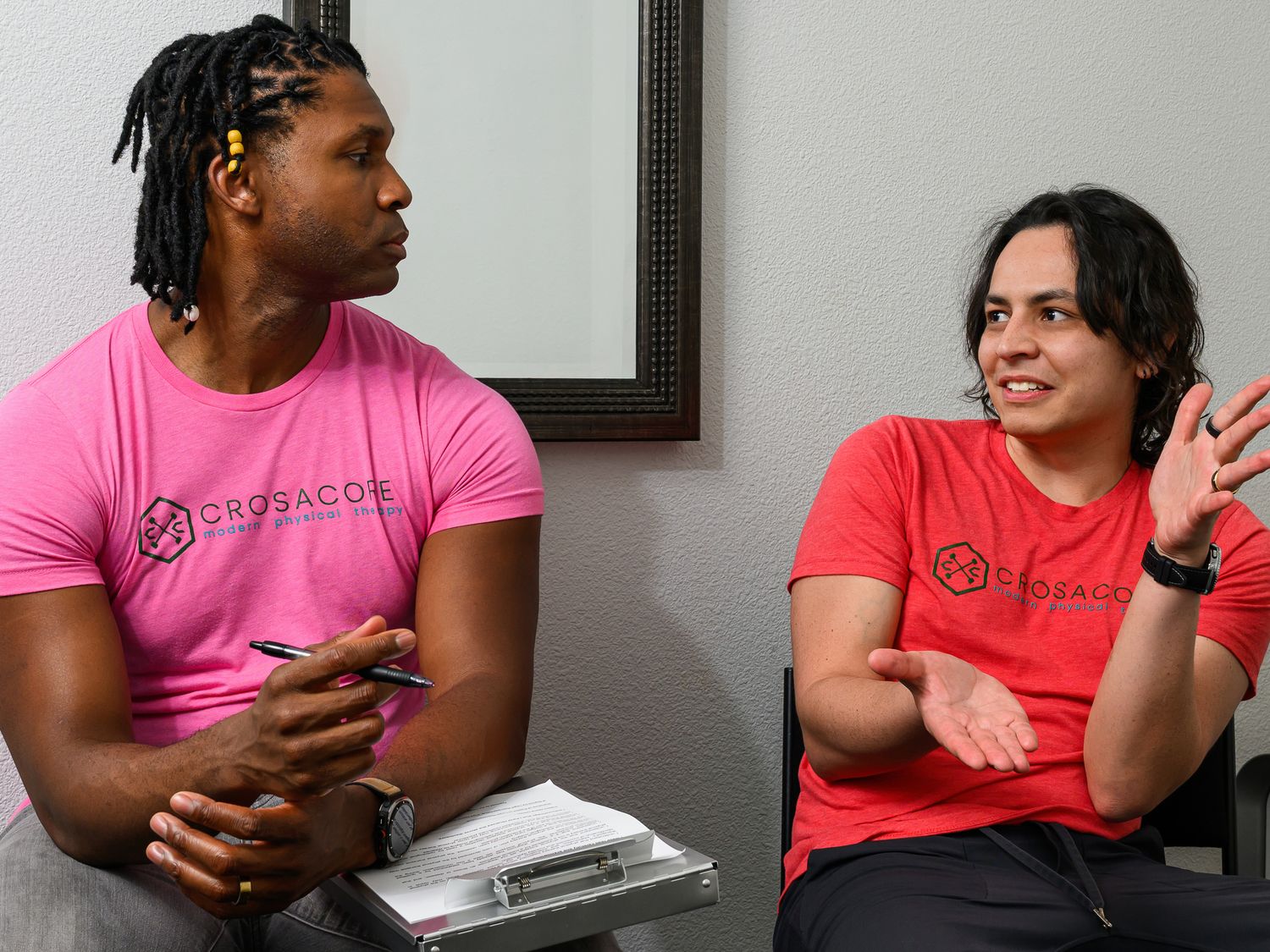 Brandon with a clipboard, reviewing a plan while a client talks it through